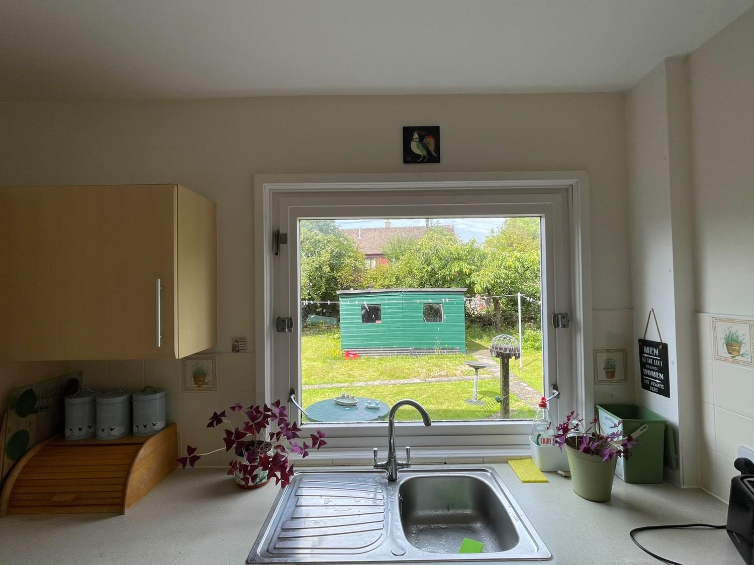 The kitchen window over the sink, looking onto the back garden